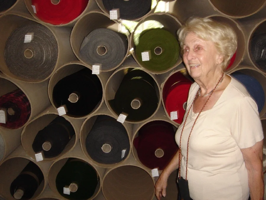 Frau Harrison vor verschiedenfarbenen Ballen von Loden