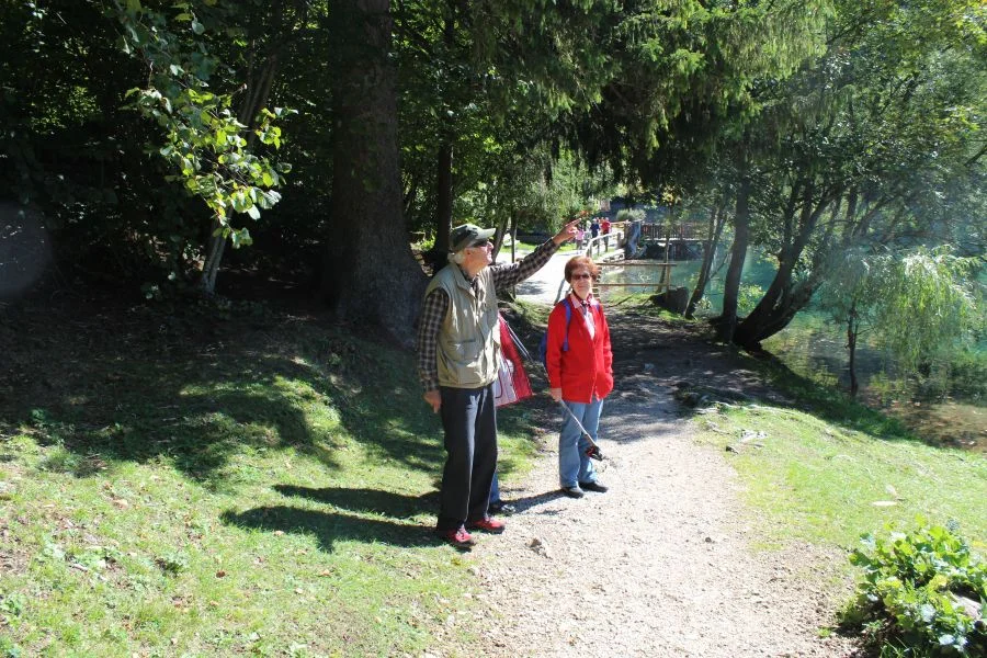 Hans Prüller zeigt gerade auf die imposante Bergkette des Mangart-Massivs.