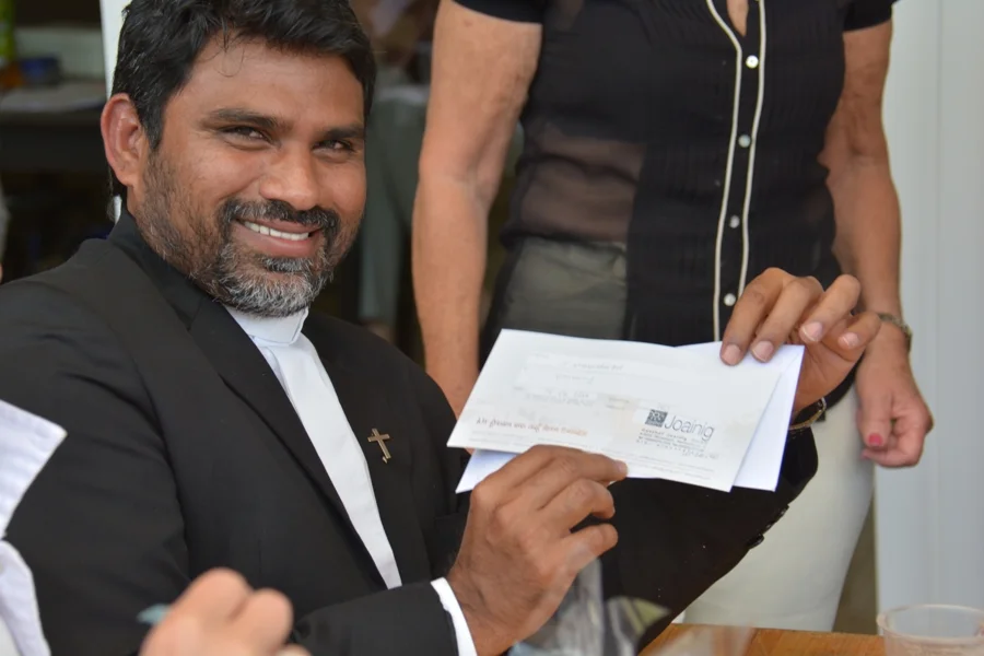 Stolz zeigte Pfarrer Joseph Mula#seinen Gewinnschein